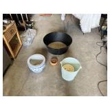 Plastic, ceramic, and metal planters including large black plastic tub and decorative blue and white ceramic pot with additional containers
