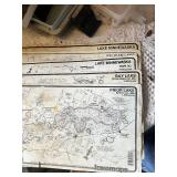 Maps, fishing guides, and fishing gear with binoculars and telescopes.