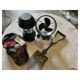 Coleman lantern, a battery-operated fan, a shovel, a water bottle, and a camouflage hat