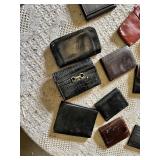 Lot of assorted wallets and small cases in various styles, materials, and colors including leather and fabric.