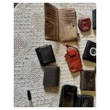 Lot of assorted wallets and small cases in various styles, materials, and colors including leather and fabric.