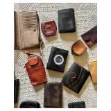 Lot of assorted wallets and small cases in various styles, materials, and colors including leather and fabric.