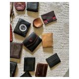 Lot of assorted wallets and small cases in various styles, materials, and colors including leather and fabric.