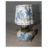 Vintage Royal Crown miniature oil lamp featuring hand-painted blue floral motifs and gold trim