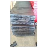 Black vinyl-covered gymnasium safety wall padding with foam core.