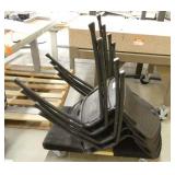 Four black plastic stacking chairs