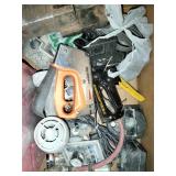 This box contains a variety of mixed garage and shop tools, including a red plastic case and a staple gun.