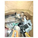 This box contains a variety of mixed garage and shop tools, including a red plastic case and a staple gun.