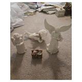 3 plaster angel figurines and a bookshelf with