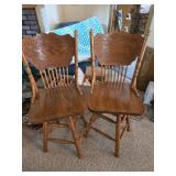 Two wooden swivel chairs
