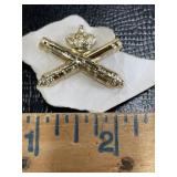 Gold tone military insignia badge with crossed