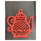 Vintage red cast iron trivet with some paint wear