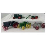 Group of five cast iron and die-cast toy farm tractors and horse drawn hand plow