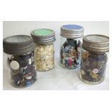 Four Glass Jars Filled With Buttons