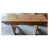 A rustic pine trestle bench