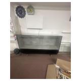 Enclosed glass shelving on wheels. 7 ft long and