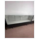 Glass shelving on wheels. 7 feet long.