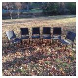 Six Black Woven-Seat Chairs with Signs of Wear