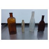 Four Glass Bottles Including Embossed Amber and Cl