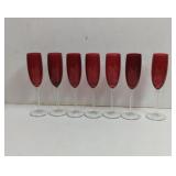 7 Red Champaign flutes with clear slender stems.