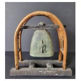 Old African bell bronze on wood support with
