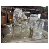 Half a shelf of mason jars some tops