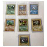 Seven Assorted Pokemon Trading Cards in Sleeves