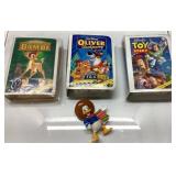 Three Disney VHS Tapes and Donald Duck Figurine