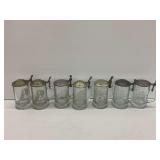 Seven Clear Glass Beer Steins with Metal Lids and Etched Designs