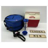 Assorted Items Including Cooler, Archery Equipment, and Restroom Signs