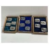 (12) Siskiyou Buckle Co. Charles M. Russell Belt Buckles and  (3) Wooden Display Cases