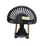 CAST IRON TRACTOR SEAT ON WOODEN STAND