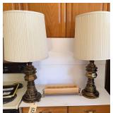 TWO TABLE LAMPS AND A CANDLE ON A STAND
