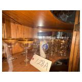 APPROX. 20 PIECES OF GOLD-TRIMMED GLASSWARE: MATCHING TUMBLERS WITH HEAVY GOLD DETAIL AND STEMWARE; FROM THIRD SHELF OF CORNER CHINA CABINET