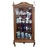SMALL ORNATE OAK CHINA CABINET WITH DETACHED CARVED UPPER-CENTER ELEMENT REQUIRING REATTACHMENT, SIDE-OPENING DOORS, AND GLASS SHELVES; APPROX. 64" TALL X 28" WIDE X 12.5" DEEP