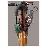 BRASS UMBRELLA STAND WITH SEVERAL UMBRELLAS AND ASSORTED WALKING CANES INCLUDED