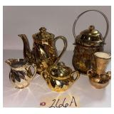GOLD-TONE TEAPOT, CREAMER, AND SUGAR, MADE IN JAPAN; EMBOSSED GOLD-TONE VASE; AMBER GLASS BISCUIT JAR IN DECORATIVE GOLD-TONE METAL HOLDER