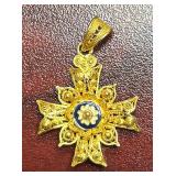 ORNATE, TRADITIONAL GOLD FILIGREE CROSS PENDANT, DELICATE SCROLLWORK W/ A SMALL BLUE-AND-WHITE ENAMEL FLORAL CENTER, CHARACTERISTIC OF HISTORIC IBERIAN (PORTUGUESE OR SPANISH) REGIONAL JEWELRY. UNMARK