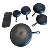 5 CAST-IRON SKILLETS: 2 MARKED NO. 5, 1 MARKED NO. 0, 1 MARKED NO. 10, 12-7/16”, 1 SMALLER UNMARKED; VINTAGE CAST-IRON CORNBREAD PAN