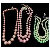 TWO MID-CENTURY PINK FAUX PEARL GRADUATED NECKLACES, ONE MULTI-STRAND, SINGLE STRAND SHOWING SIGNS OF WEAR, ONE MID-CENTURY MULTI-STRAND NECKLACE WITH JADE COLOR GRADUATED FAUX PEARLS