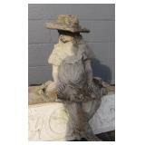 Girl Sitting on Dress With Hat Statue