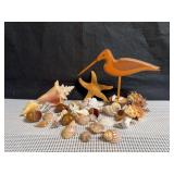 Carved wooden shorebird signed by the artist, and a collection of seashells