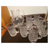 Pitcher and eight mugs with floral designs. The pitcher and mugs do not match exactly