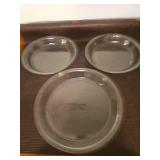 Three Pyrex pie plates, two 9in and one 11in.