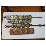 Collection of horse brasses (harness medallions) displayed on leather straps, one of which is mounted on a board