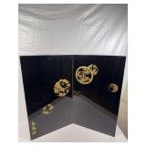 Vintage Japanese ￼ wooden folding screen ￼ with a black lacquered finish, gold painted designs, and gold metal accent pieces on two corners ￼ ￼