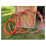 Coils of heavy-duty red-orange industrial hose