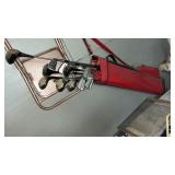Golf clubs and chair on wall