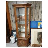 Lighted curio cabinet with storage at bottom.