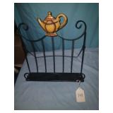 Metal recipe book stand with teapot on top.